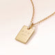 Personalised square gold necklace with white zirconia seen from the side, with initials, a heart and a year engraved on the front