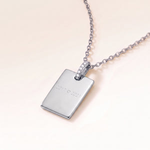Personalised square silver necklace with white zirconia seen from the side, with years and a heart engraved on the front