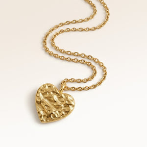 Personalized heart-shaped gold necklace with softly melted finish and space for engraving of text, coordinates or handwriting on the back