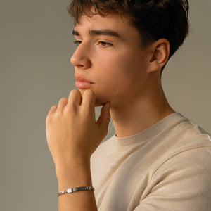 Model wearing personalized bar bracelet for men in silver with space for engraving of text or handwriting