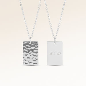 Personalized square silver necklace with rippled wave surface and space for engraving of text, coordinates or handwriting on the back