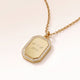 Close-up of an octagon gold pendant with white zirconia around the edge and a personal engraving of initials with a heart and a year