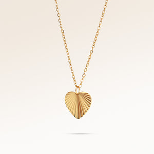 Minimalist heart-shaped gold necklace with sunburst pattern and space for engraving of text, coordinates or handwriting on back.